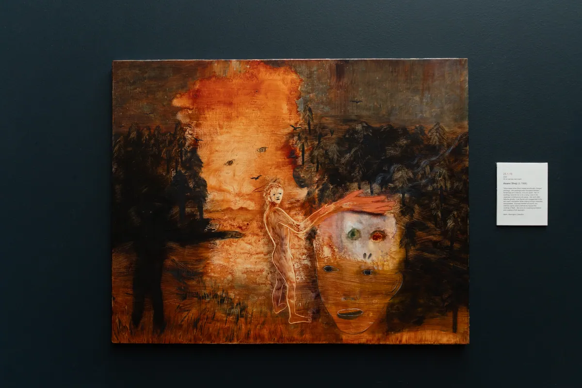 The painting on a dark navy wall at TolHouse with its wall label alongside