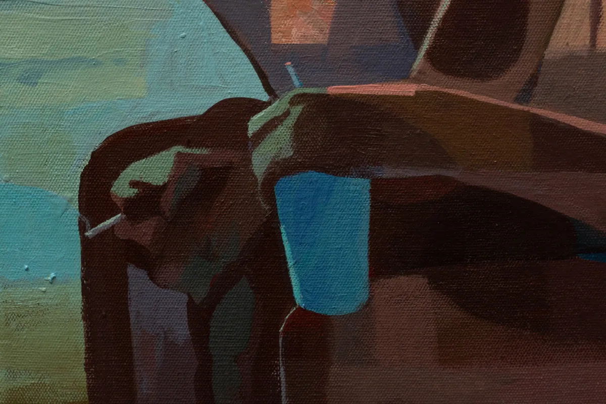 Detail of a hand, a cigarette and a blue plastic cup on the chair arm
